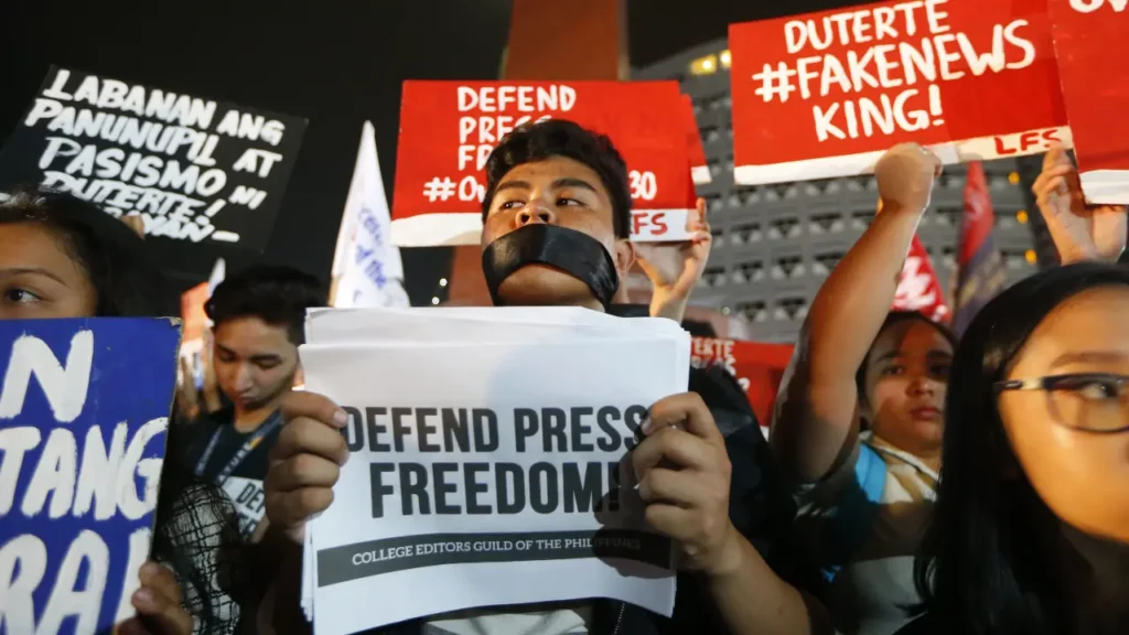 Image of journalists covering protests, highlighting threats to press freedom.